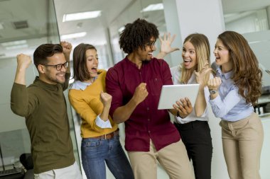 Mutlu ve başarılı gençler modern bir ofiste duruyor