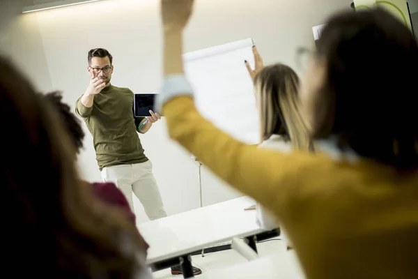 Grupa Młodych Studentów Rosnących Rąk Aby Odpowiedzieć Pytanie Podczas Szkolenia — Zdjęcie stockowe