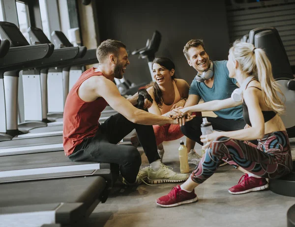 Freunde in Sportkleidung reden und lachen beim Sitzen miteinander — Stockfoto