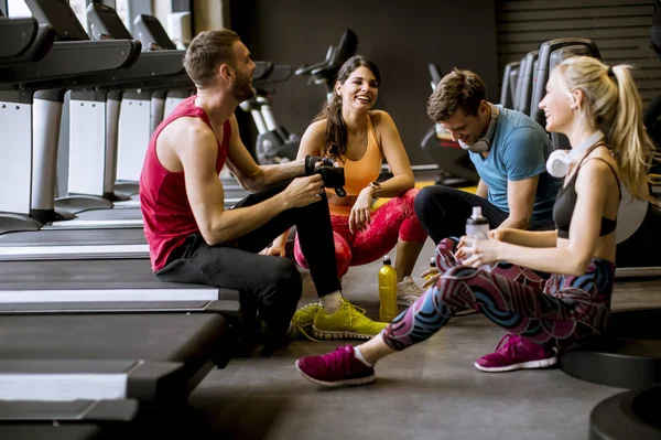 Sittin yaparken spor giyim arkadaşlar konuşma ve birlikte gülüyor — Stok fotoğraf