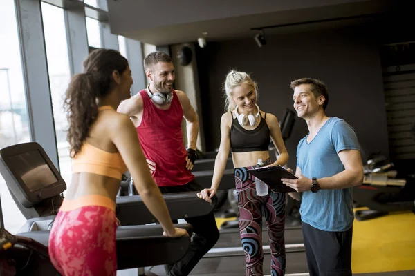 Vänner i sportkläder prata tillsammans medan du står i ett gym — Stockfoto