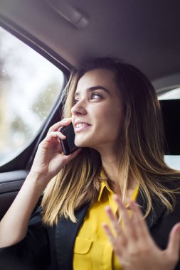 Cep telefonu arabada konuşurken genç iş kadını