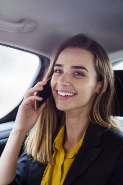 Cep telefonu arabada konuşurken genç iş kadını