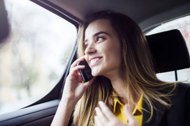 Arabada cep telefonuyla konuşan genç iş kadınının portresi