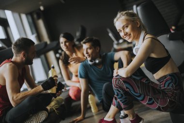 Spor salonunda konuşan bir grup spor kıyafeti antrenmandan sonra