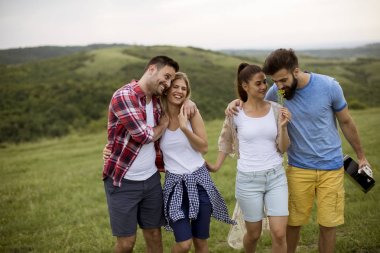 Yaz alanında yürüyen akustik gitarile mutlu gençler grubu