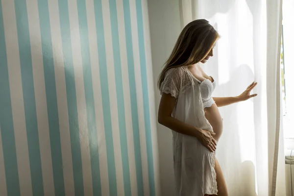 Jolie Jeune Femme Enceinte Debout Fenêtre Près Mur Bleu Dépouillé — Photo