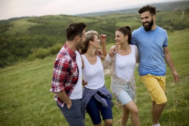 Yaz tarlasında yürüyen mutlu gençler grubu