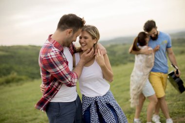 Yaz alanında yürüyen akustik gitarile mutlu gençler grubu