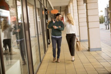 Şehirde kağıt alışveriş torbaları ile genç çift portresi