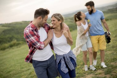 Yaz alanında yürüyen akustik gitarile mutlu gençler grubu