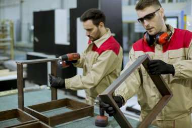 Fabrikada mobilya montajı iki yakışıklı genç işçi