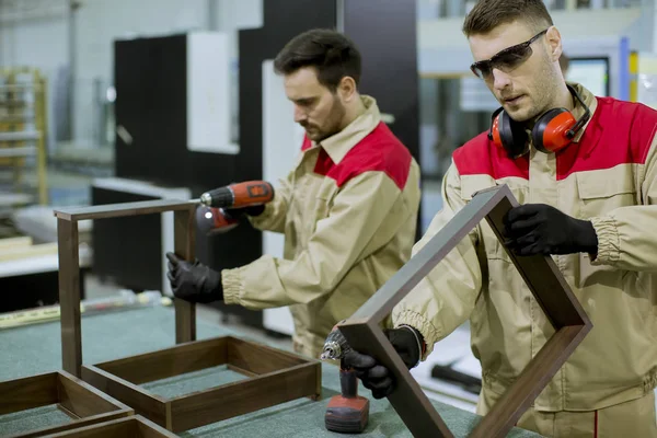 Dois Jovens Bonitos Trabalhadores Montando Móveis Fábrica — Fotografia de Stock