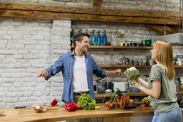 素朴なキッチンで市場から野菜を皮むいて切るトレンディなカップル — ストック写真