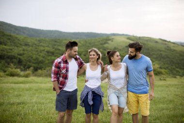 Yaz tarlasında yürüyen mutlu gençler grubu