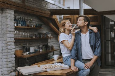 Genç aşık çift kırsal kesimde salya sümük pizza yiyor.