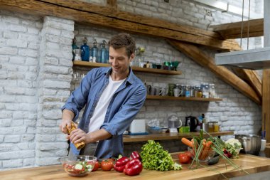 Rustik mutfakta yiyecek hazırlayan yakışıklı genç adam