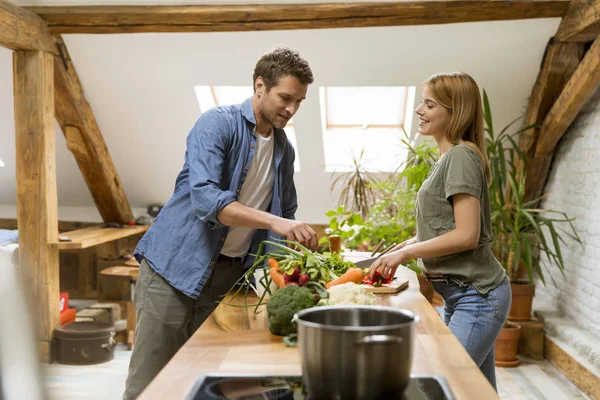 素朴なキッチンで市場から野菜を皮むいて切るトレンディなカップル — ストック写真