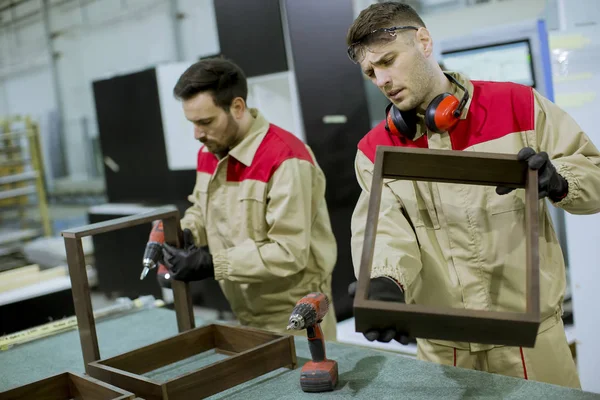 Dois Jovens Bonitos Trabalhadores Montando Móveis Fábrica — Fotografia de Stock