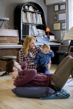 Evde eğlenen mutlu aile odada yerde oynayarak