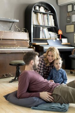 Evde eğlenen mutlu aile odada yerde oynayarak