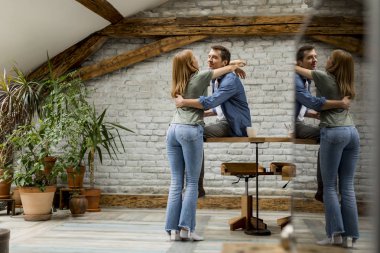 Sevimli çift rustik odada sarılmak