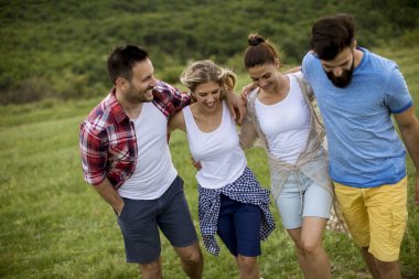 Yaz tarlasında yürüyen mutlu gençler grubu