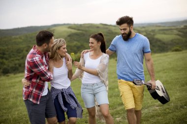Yaz alanında yürüyen akustik gitarile mutlu gençler grubu