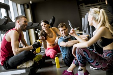 Spor salonunda konuşan bir grup spor kıyafeti antrenmandan sonra