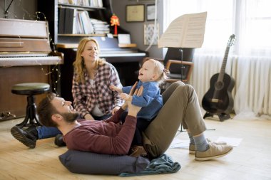 Evde eğlenen mutlu aile odada yerde oynayarak