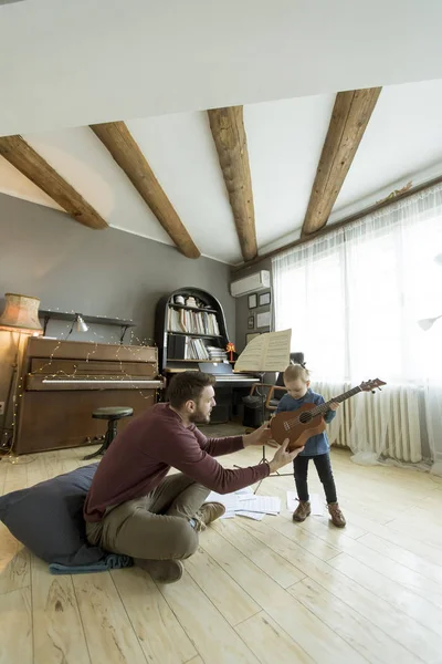 Jovem Pai Ensinando Sua Filhinha Fofa Para Tocar Guitarra Enquanto — Fotografia de Stock