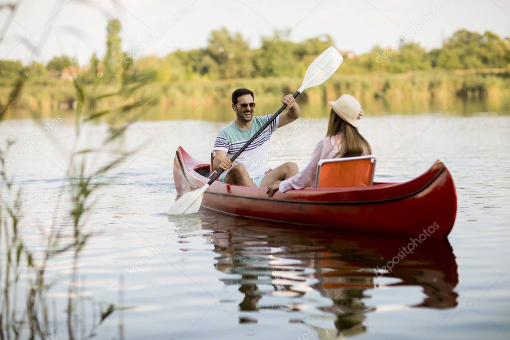 Loving couple rowing on the lake at summer day