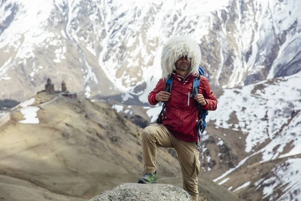 View at young hiker with traditional papakha fur hat at high latitude mountains at Mtskheta-Mtianeti region in Georgia