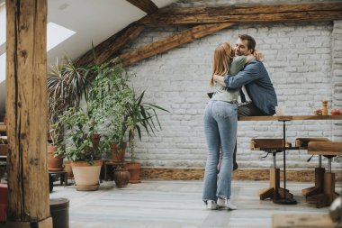 Sevimli genç çift kendi daire mutfağında yemek yaparken sarılma