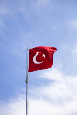 Mavi gökyüzünde rüzgarda sallanan Türk bayrağının görüntüsü