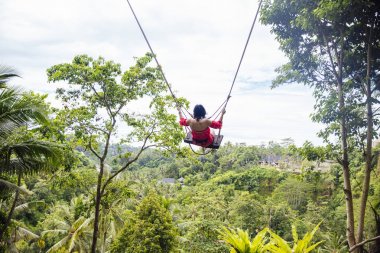 Bali adasında tropikal yağmur ormanları üzerinde sallanan genç turist kadın, Endonezya