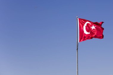 Mavi gökyüzünde rüzgarda sallanan Türk bayrağının görüntüsü