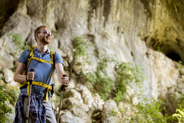 Güneşli bir günde sırt çantası ile yakışıklı genç beyaz erkek yürüyüşçü