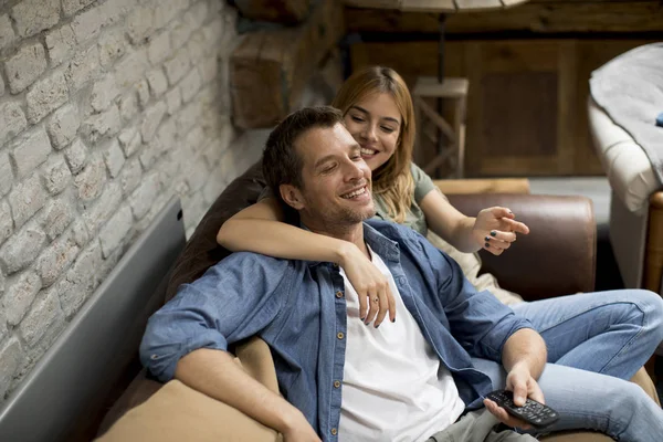 微笑可爱的年轻夫妇放松和看电视在家里 — 图库照片
