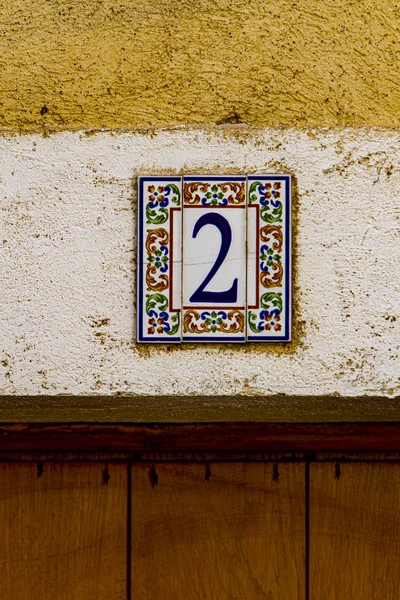 Traditional decorative street number plate from facade of old house in Nimes, France