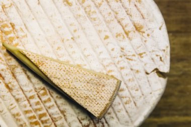 Ahşap masadaki Fransız Le Marcaire peynirinin detayı