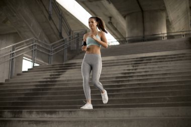 Kentsel ortamda açık merdivenlerden aşağı tek başına çalışan Pretty genç kadın