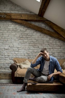 Apartman odasında oturan stresli genç adam