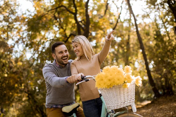 一对活泼的年轻夫妇在金秋公园骑自行车玩得很开心 — 图库照片