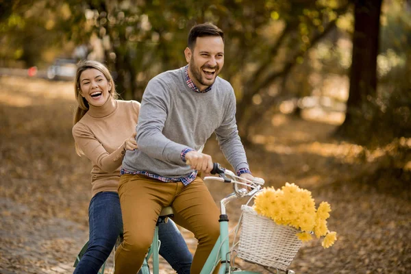 一对活泼的年轻夫妇在金秋公园骑自行车玩得很开心 — 图库照片