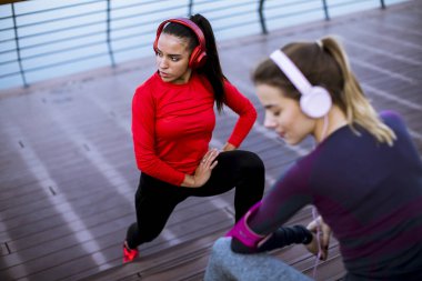 Şehir ortamında jimnastik yapan iki genç kadın.