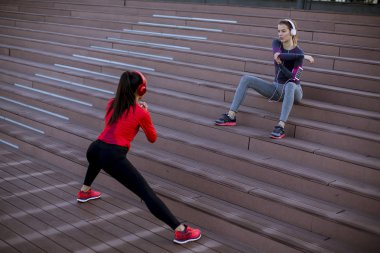 Şehir ortamında jimnastik yapan iki genç kadın.