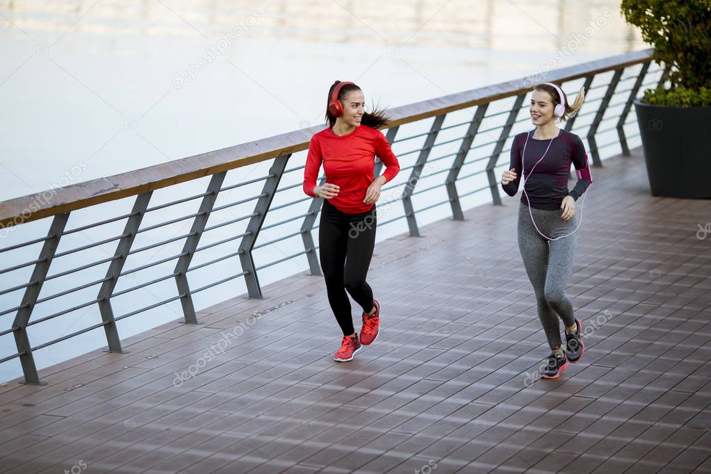 Scenery of two female joggers pursuing their activity in urban outdoors