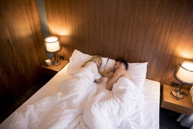 Evlerinde yataklarında kucaklaşan sevimli genç bir çift.