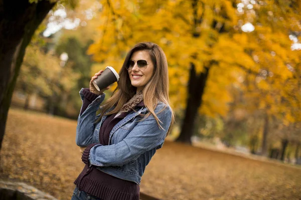 Genç Bayan Sonbahar Parkında Kahve Içiyor — Stok fotoğraf